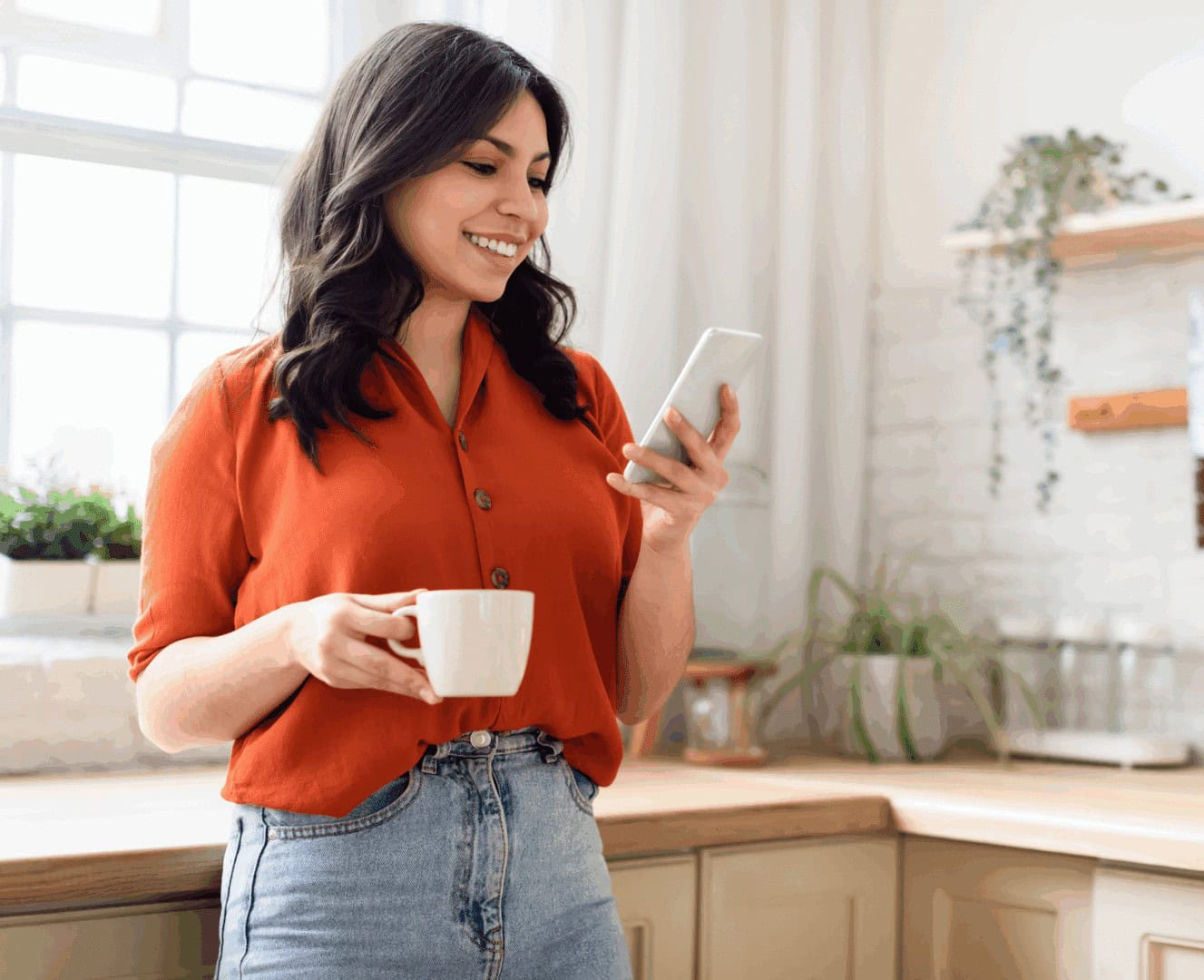 Person holding cup, using smartphone