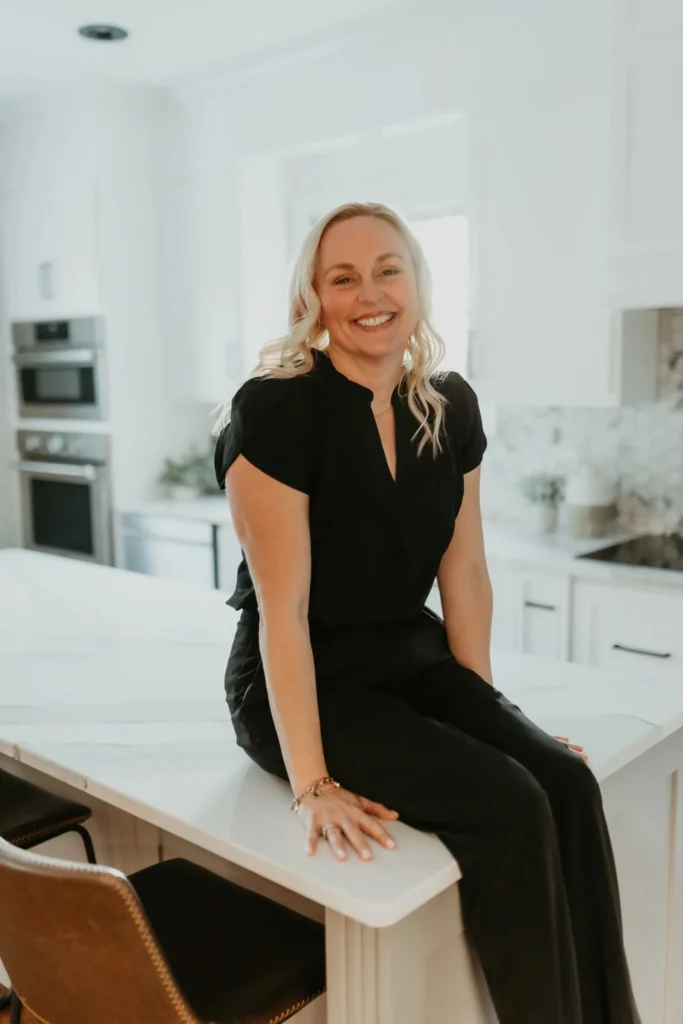 Smiling woman sitting on white kitchen island