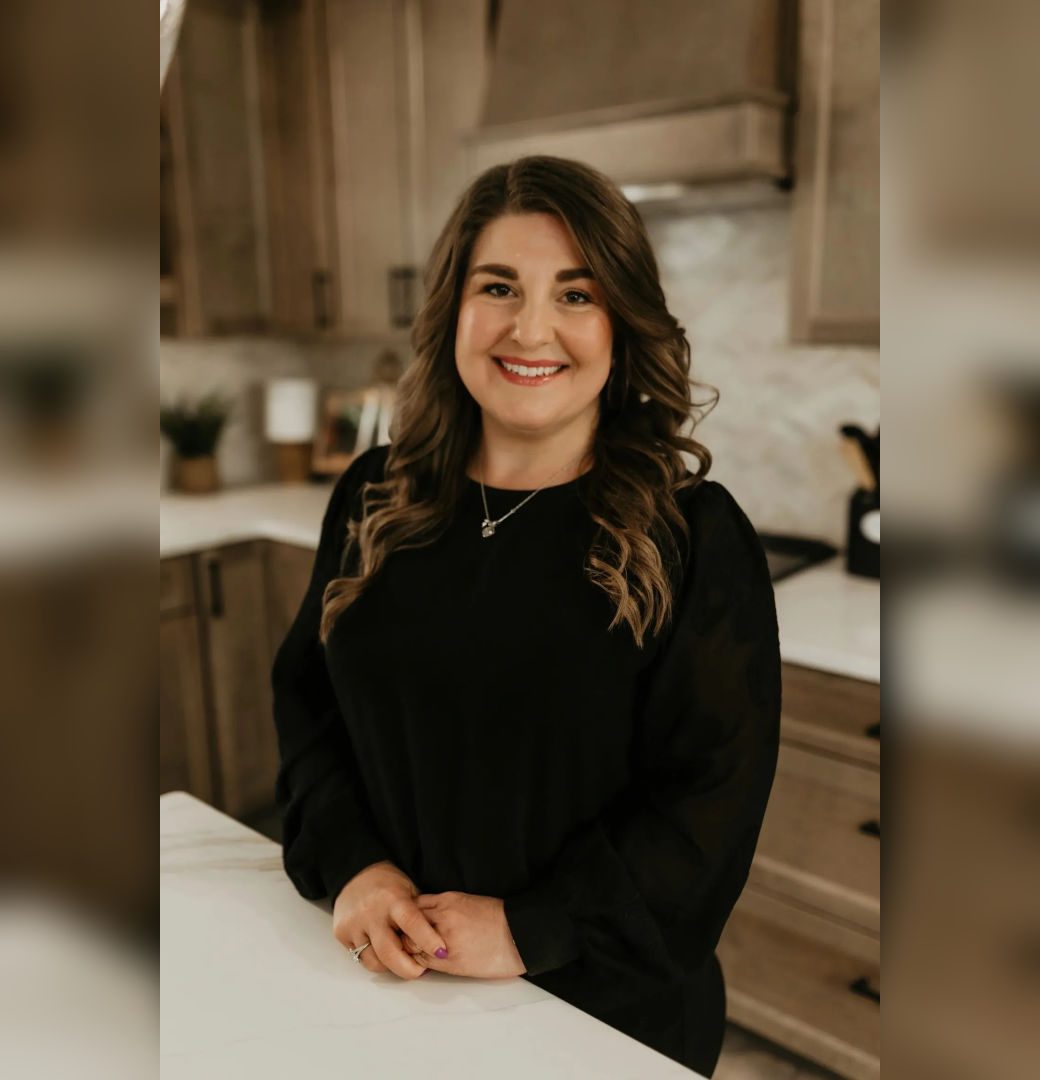 Smiling woman in kitchen with wavy hair