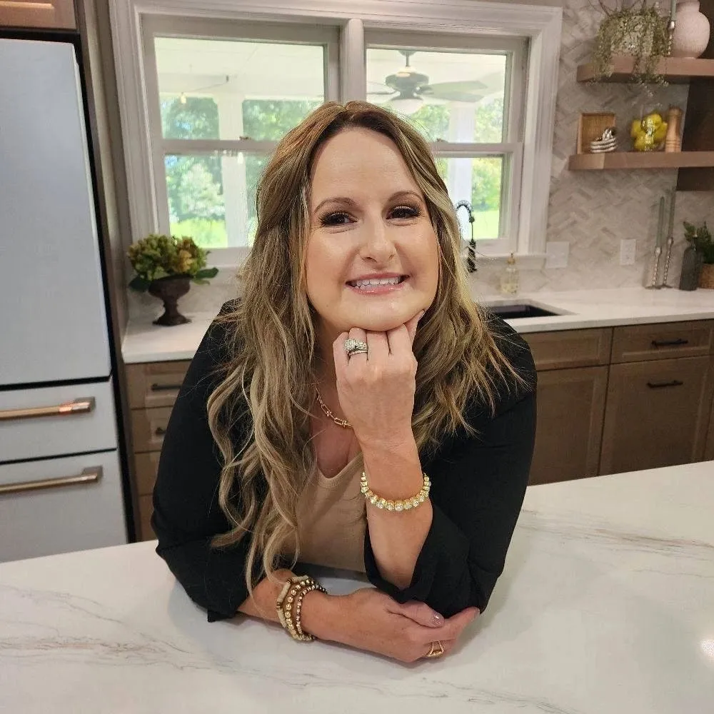 Smiling woman leaning on marble kitchen counter