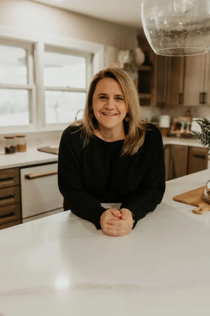 Smiling woman leaning on kitchen counter