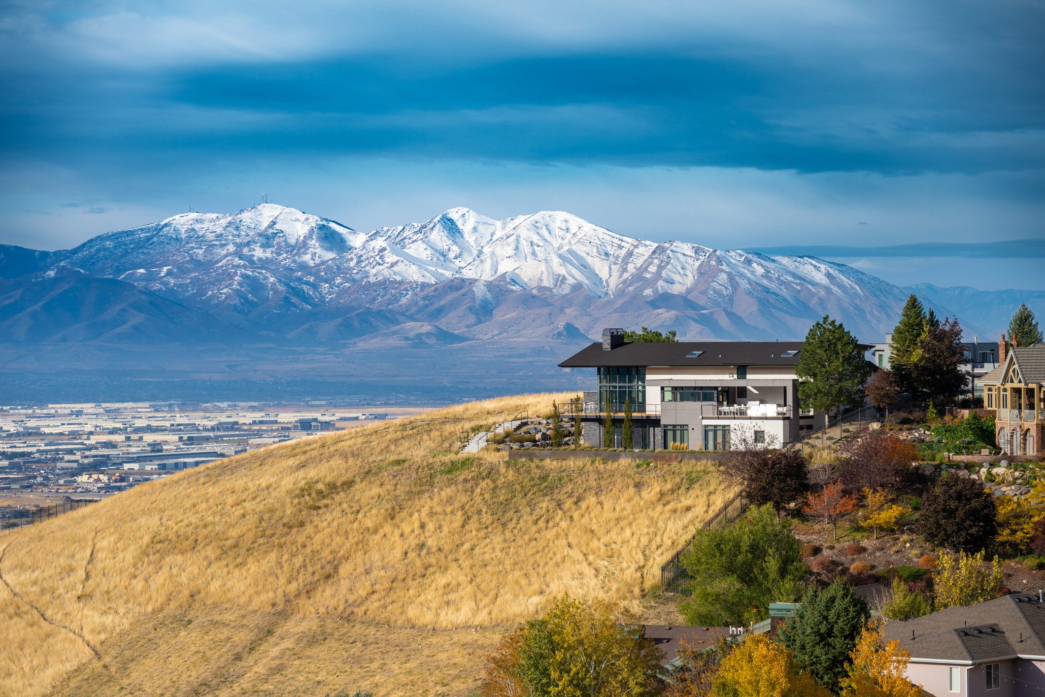 Modern hillside homes with snow-capped mountains