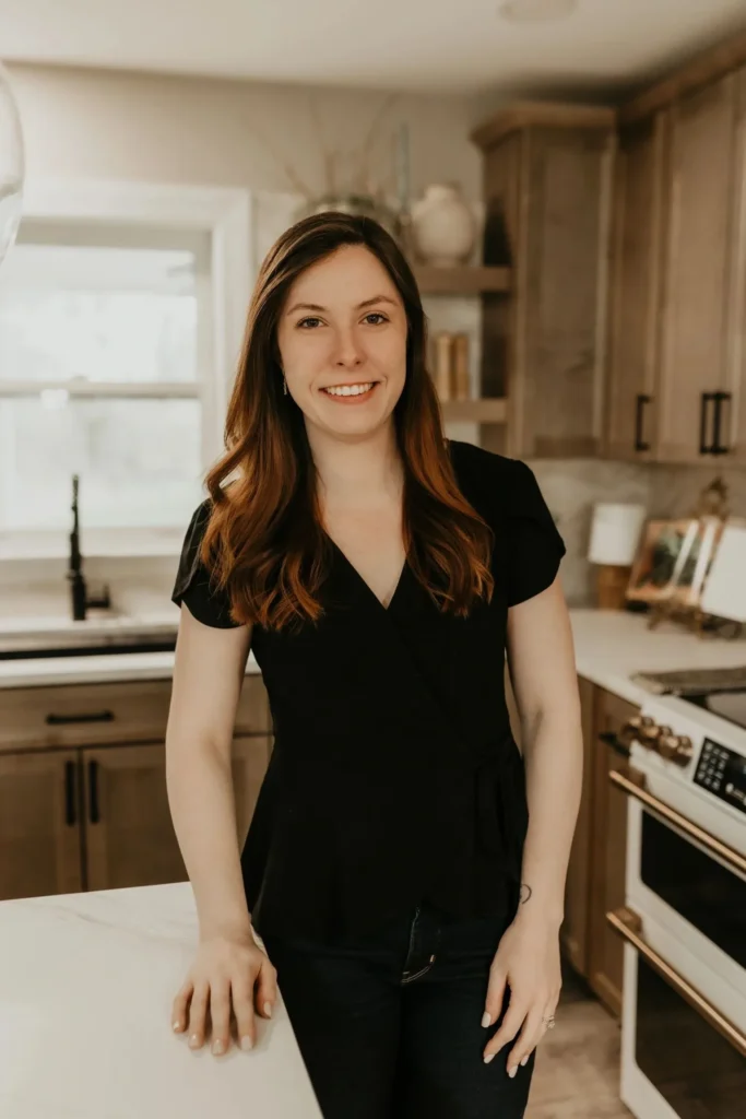 Smiling young woman standing at kitchen counter