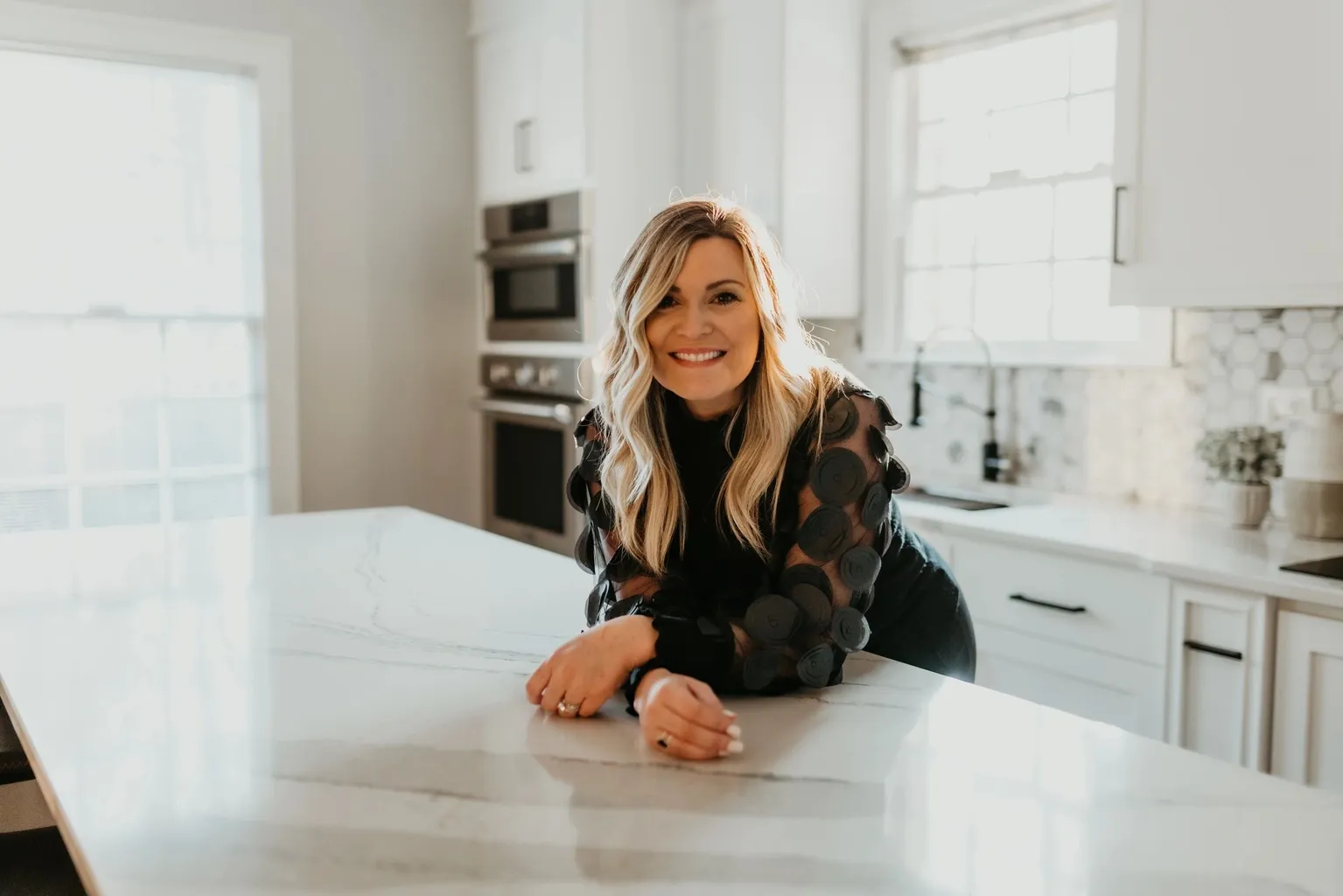 Smiling woman leaning on modern kitchen island