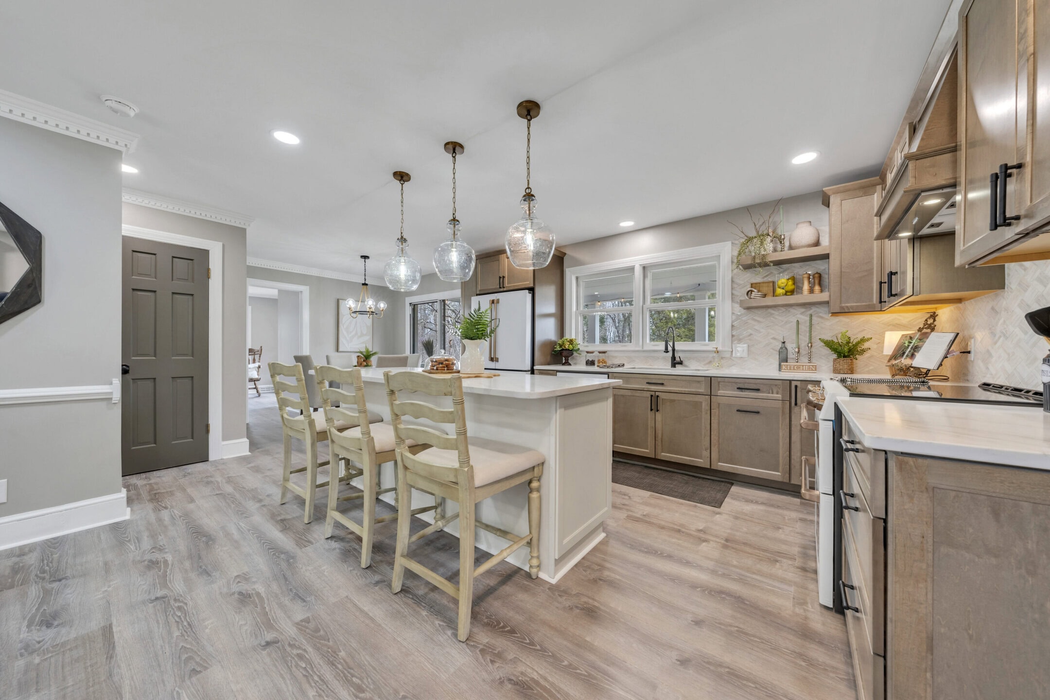 Spacious modern kitchen with island, pendant lights, and wooden cabinets.